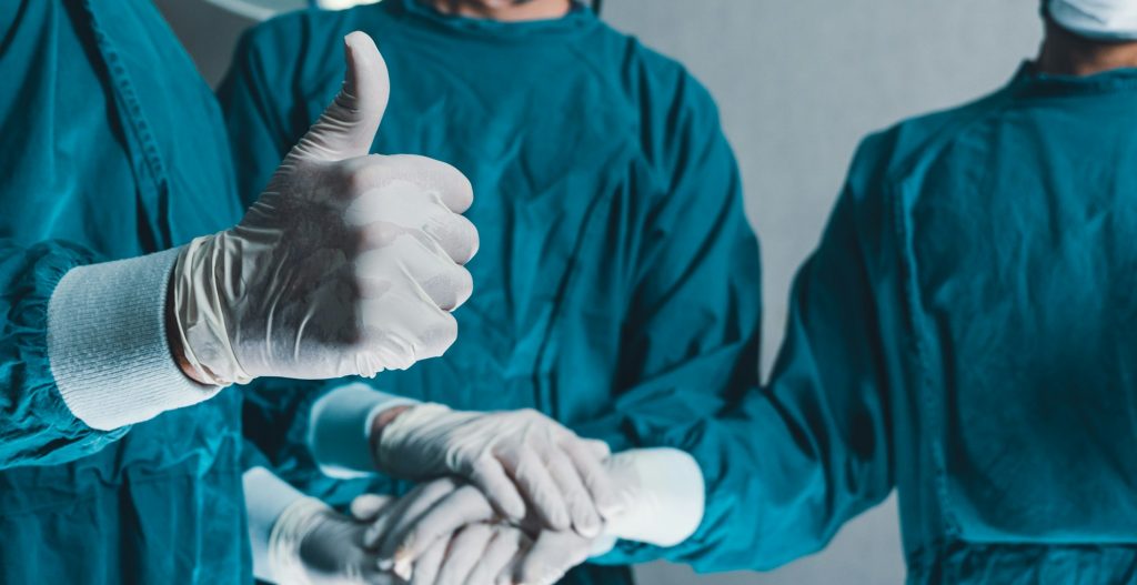 Medical surgeon team put hand together and showing thumb up