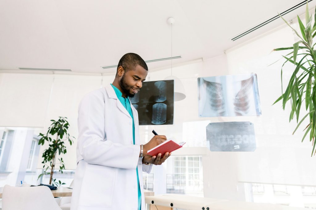 Medicine, oncology, tumour. Professional African male oncologist looking at the X-ray photos of the